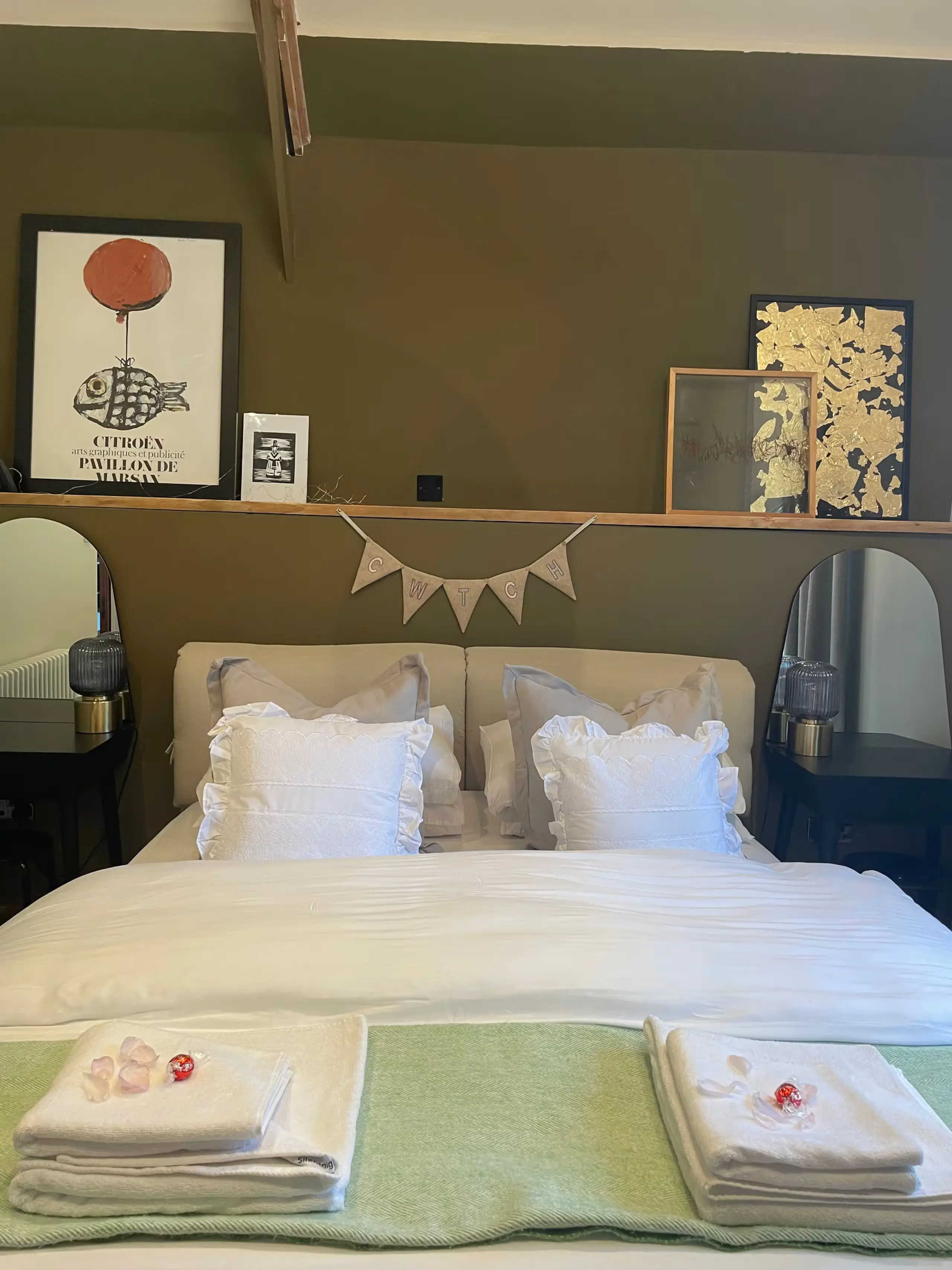 King-size bed made up with white linen, fresh towels and welcome treats