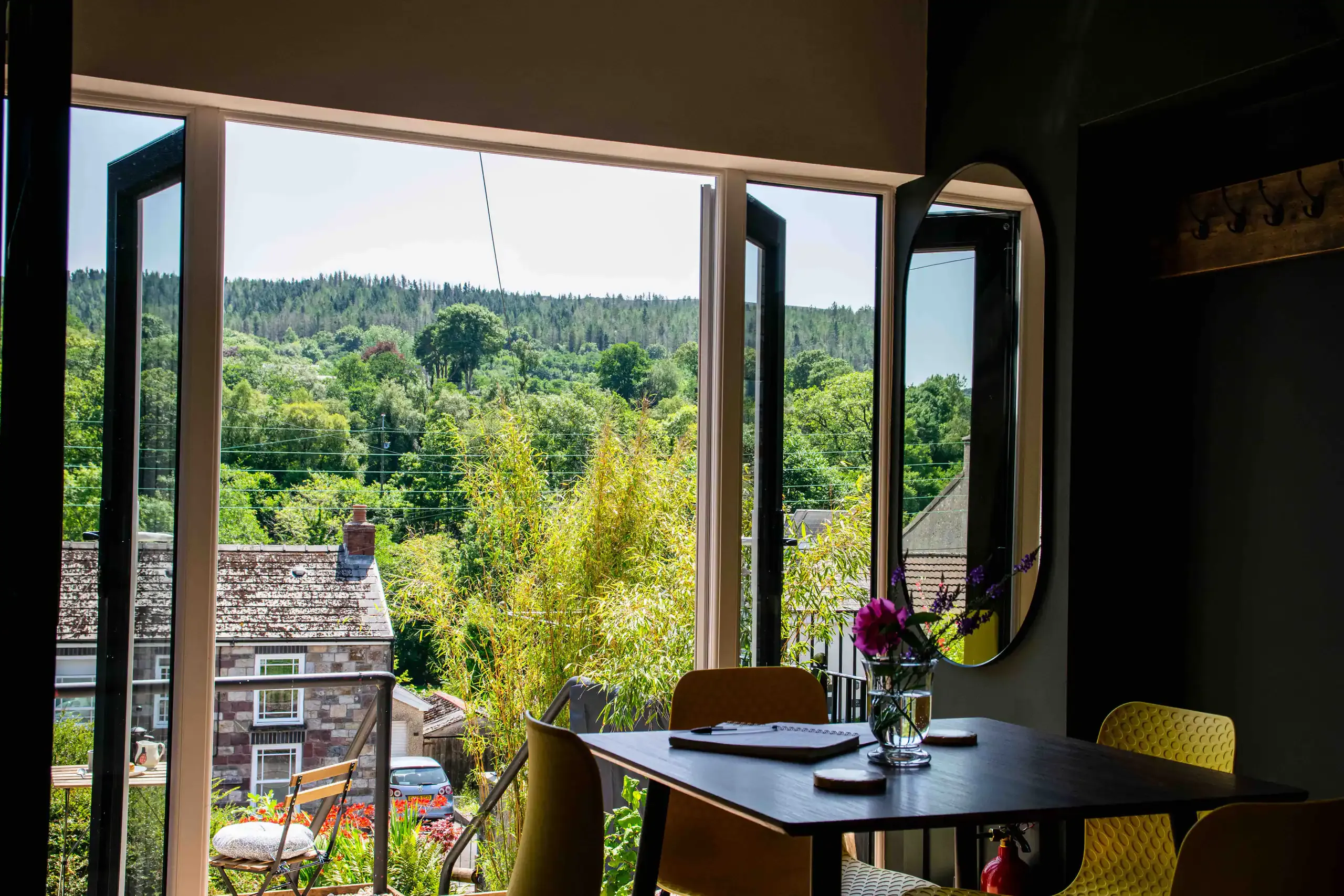 Open windows at The Old Exchange framing a view of the wooded hillside above Abercraf